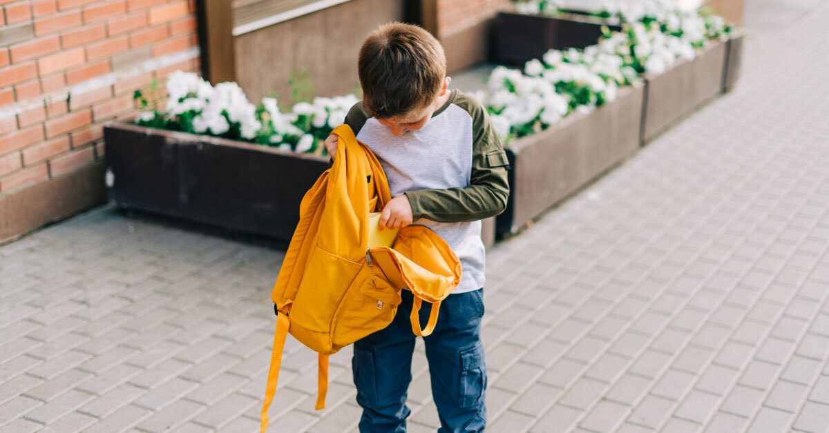 22 февраля идут в школу. Child holding Backpack. Мальчик держит рюкзак. Мальчика держат за рюкзак.