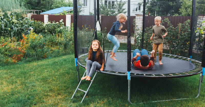 Kilkuletnie dzieci spędzające czas, skacząc na trampolinie.
