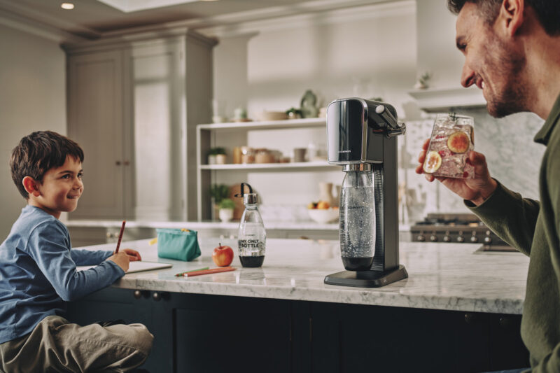 Tata i syn zadowoleni w kuchni przy butelce Sodastream